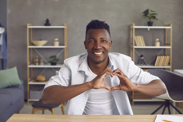 Man blogger opnemen video en tonen hart gebaar als een teken van liefde voor zijn volgelingen. — Stockfoto