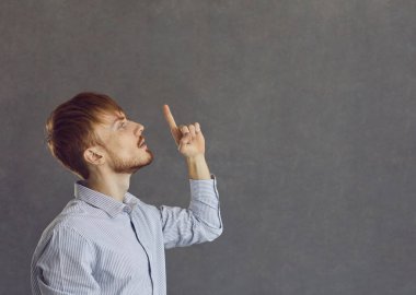 Kafkasyalı bir adam, stüdyo fotoğrafına bakıp işaret etmeyi düşünüyor.