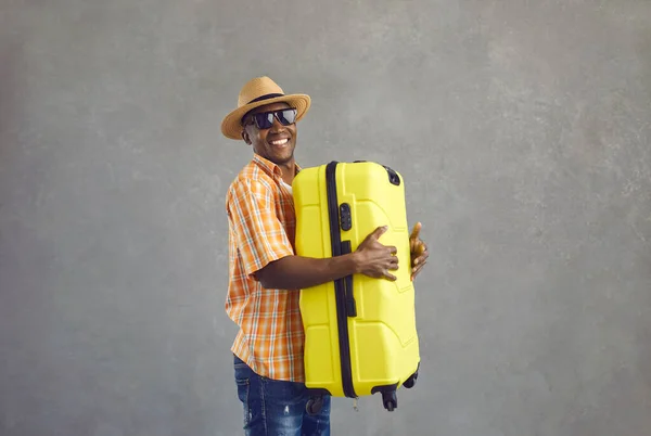 노란 여행 가방을 들고 웃고 있는 행복 한 흑인 관광객의 스튜디오 사진 — 스톡 사진