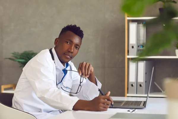 Afroamerikanische Ärztin sitzt mit Laptop am Tisch — Stockfoto
