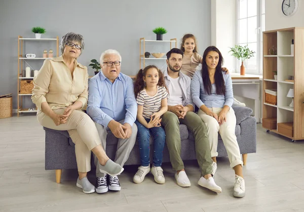 Portrait à domicile d'une grande famille avec des grands-parents et des enfants montrant une émotion étonnante — Photo