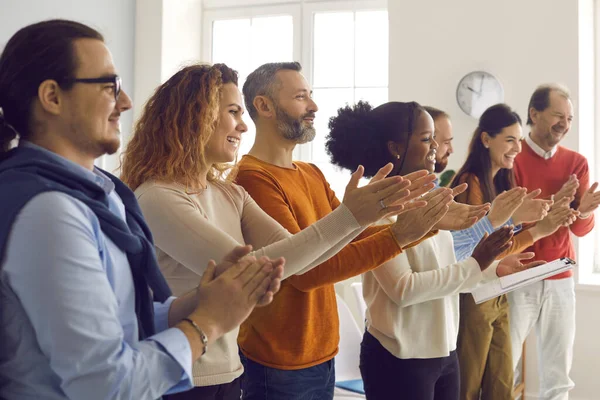 Gruppe fröhlicher unterschiedlicher Menschen applaudiert und dankt Redner für vergnügliche Präsentation — Stockfoto