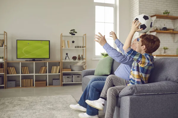 Starszy dziadek i nastoletni fan wnuków oglądają mecz piłki nożnej w domu — Zdjęcie stockowe