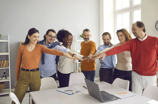 Glad mångsidig team av entusiastiska affärsmän gå hand i hand i grupp office möte — Stockfoto