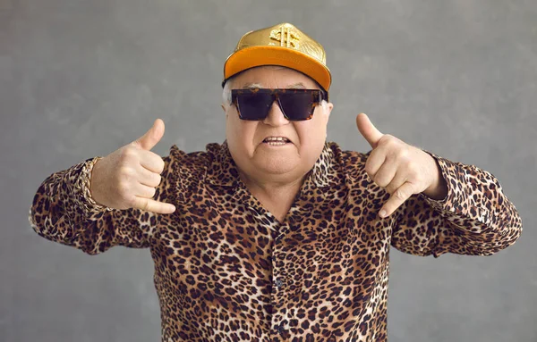 Divertente uomo anziano ricco in berretto da baseball, occhiali e camicia leopardo godendo la musica e divertirsi — Foto Stock