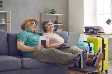 Mutlu yaşlı çift yaz tatiline hazırlanıyor ve otel odasını internetten ayırtıyor.