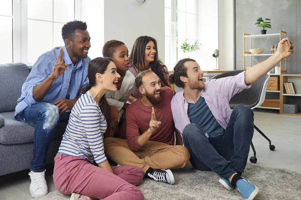 Grupo multirracial de jóvenes amigos felices tomando una selfie en un teléfono móvil moderno — Foto de Stock