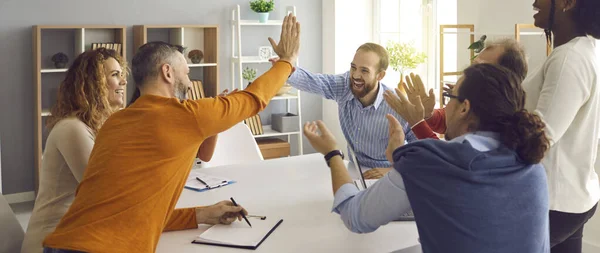 Šťastný obchodní tým tleskání rukou, zatímco dva kolegové dává vysoké pět gest — Stock fotografie