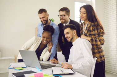 Birlikte dizüstü bilgisayara bakan iş adamları grubu çevrimiçi konferans yapıyorlar.