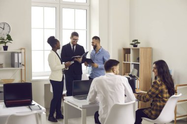 Şirket ofisinde ya da ortak çalışma alanında birlikte çalışan mutlu yaratıcı iş adamları