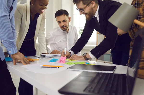 Direttore creativo che scrive con il mercato sulla nota di idea adesiva per il progetto del team — Foto Stock