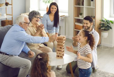 Mutlu büyük bir aile hep birlikte evlerinde tahta kule masa oyunu oynuyorlar.
