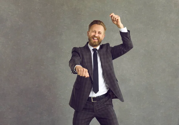 Portret van een gelukkige zakenman dansen gangnam stijl tegen grijze studio achtergrond — Stockfoto