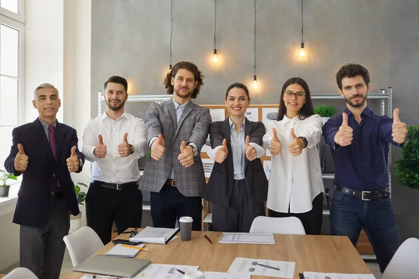 Equipe de trabalhadores da empresa feliz dando polegares para cima após a reunião de negócios bem sucedida — Fotografia de Stock