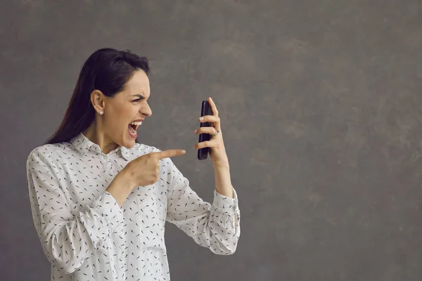 Raiva mulher agressiva nervosamente gritando olhando com ódio na tela do telefone móvel. — Fotografia de Stock
