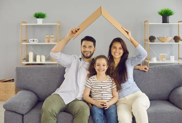 Portrait of happy young European family with daughter relax under roof celebrate relocation to own home.