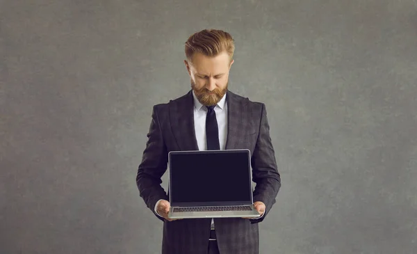 Studio shot hombre de negocios muestra pantalla en blanco pantalla negra portátil monitor de texto — Foto de Stock