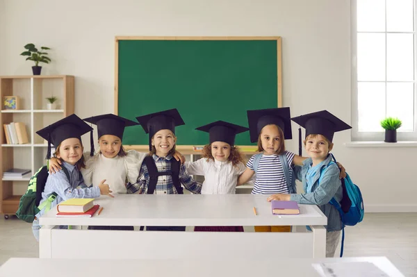 Портрет групи випускників дитячого садка або молодшого класу у бакалаврському капелюсі або мінометному . — стокове фото
