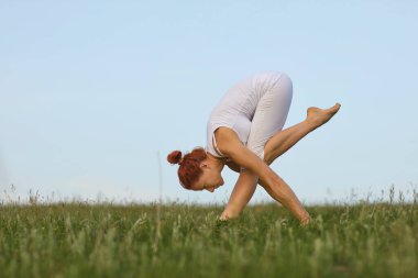 Yoga yaparken orta yaşlı kadın Mütevazi Flamingo pozu veriyor.