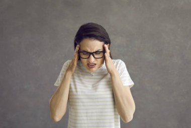 Stresli genç kadın kendini güçlü hissediyor. Korkunç baş ağrısı stüdyo çekimi