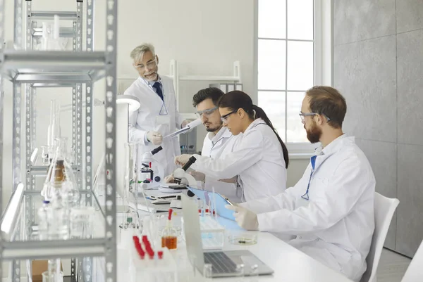Groep van verschillende medische wetenschappers werken samen in een modern wetenschappelijk laboratorium. — Stockfoto