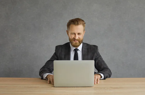 Feliz sorridente empresário sentado na mesa usando laptop estúdio tiro retrato — Fotografia de Stock