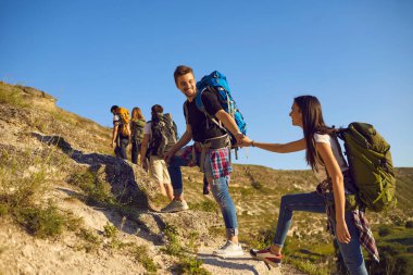 Dağlarda yürüyüş yapan bir grup turist. Sırt çantalı, açık havada dağcılık yapan aktif gençlerden oluşan bir ekip.