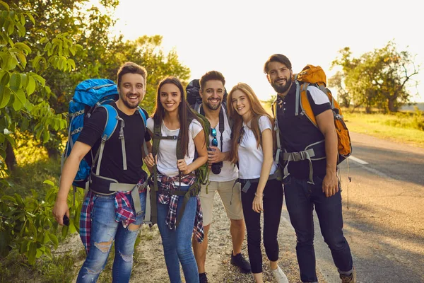 Groupe de jeunes touristes randonneurs debout et regardant ensemble la caméra pendant les vacances d'été — Photo