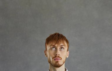 Genç adam fotokopi arkaplanında bir şey görüyor, hayal ediyor ya da hayal ediyor.