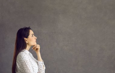 Genç düşünceli kadın çenesini tutup geleceği düşünüyor ya da bir karar veriyor..