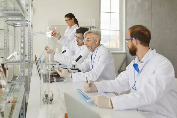 Groep wetenschappers doet geavanceerd wetenschappelijk onderzoek in modern medisch laboratorium — Stockfoto