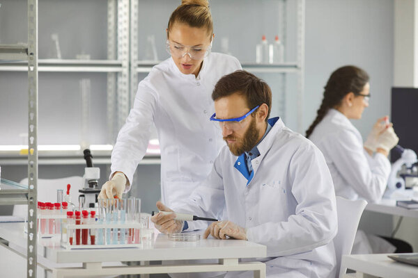 Group of serious scientists working in a pharma or biotech scientific laboratory