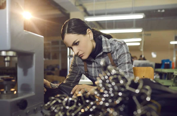 Vrouwelijke werkneemster maakt nieuwe leren laarzen bij productiewerkplaats in schoenfabriek — Stockfoto