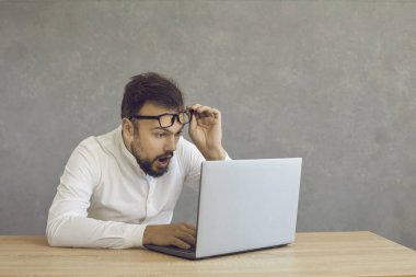 Genç adam internette bilgisayar ekranına bakarak para kazanmasına şaşırdı.