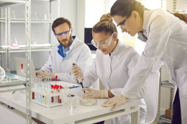 Bir ilaç veya biyoteknoloji laboratuvarında deney yapan bir grup bilim adamı