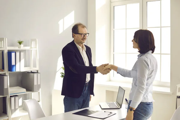 Bank worker, loan adviser or insurance agent shaking hands with client in his office — Stock Photo, Image