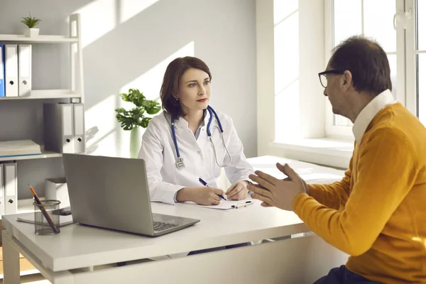 Mężczyzna w średnim wieku na oddziale szpitalnym konsultuje się z lekarzem o jego zdrowiu.. — Zdjęcie stockowe