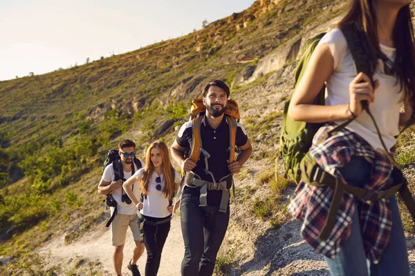 Um grupo de turistas com mochilas em uma caminhada na natureza. — Fotografia de Stock