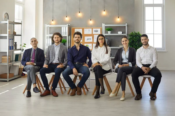 Gruppporträtt av personer som sitter i rad under affärsmöte eller utbildningsföreläsning — Stockfoto