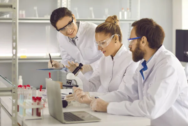 Groep jonge wetenschappers werkzaam in een modern farmaceutisch of biotechnisch laboratorium — Stockfoto