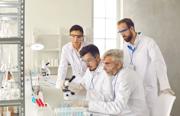 Grupo de cientistas diversos discutindo relatório de pesquisa em laboratório — Fotografia de Stock