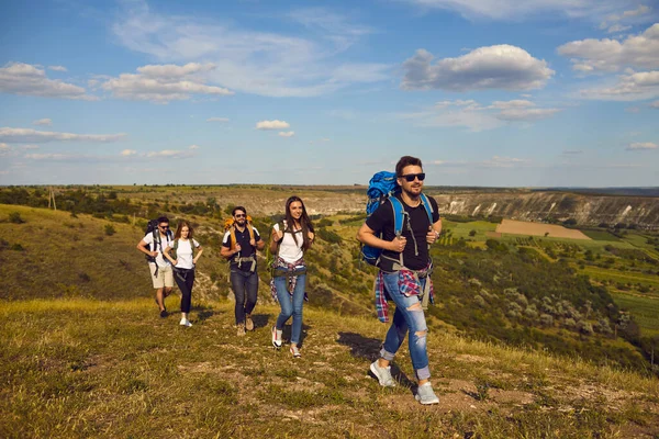 Skupina mladých turistů turistů turistika spolu s údolím krajiny v pozadí — Stock fotografie