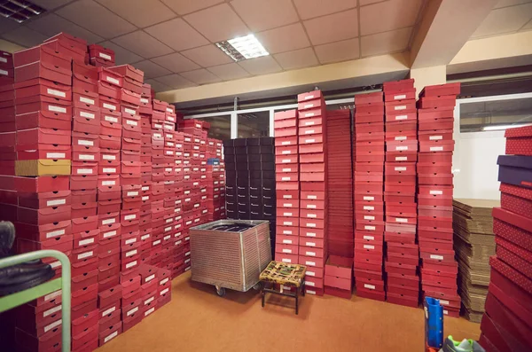 Skladiště obuvnické továrny se spoustou krabic od obuvi naskládaných na sebe — Stock fotografie
