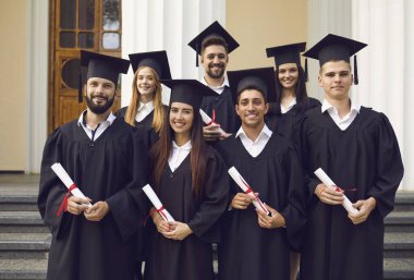 Bir grup mutlu öğrenci havan topu ve bekarlığa veda elbisesi içinde başarıyı kutluyorlar..