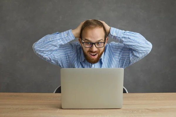Mutlu, şoke olmuş, beyaz bir adam dizüstü bilgisayar stüdyosunun çekimlerine bakarak çığlık atıyor. — Stok fotoğraf