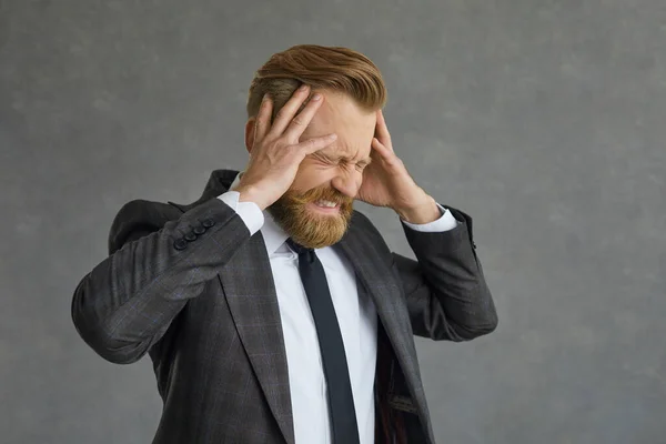 Businessman in formal suit suffering from terrible headache studio shot — 스톡 사진