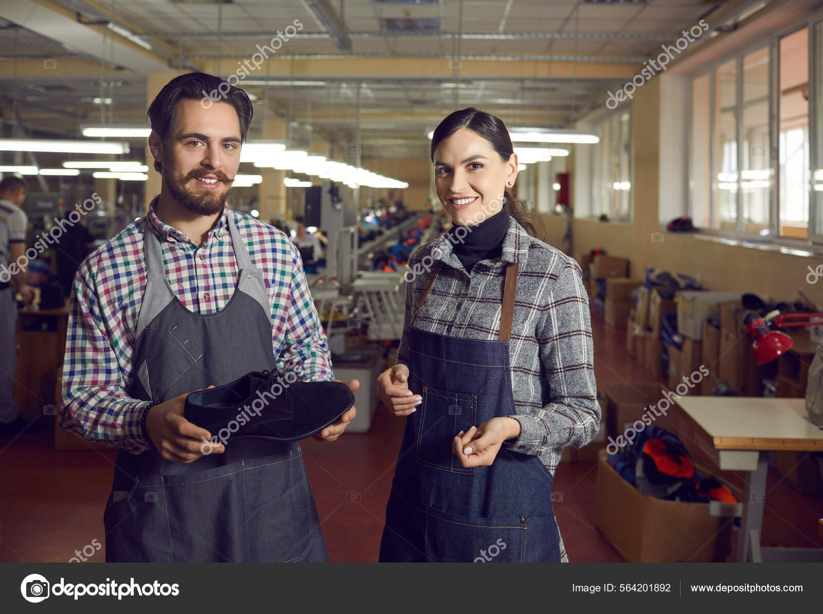 Two diverse shoemaker in uniform smiling posing for camera with