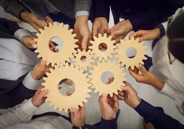 Grupo de empresários se juntam ao cogwheels como metáfora para o trabalho em equipe e a eficiência do trabalho — Fotografia de Stock
