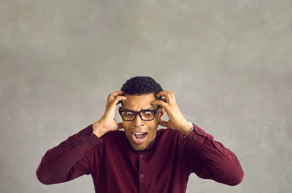 Portret van een bange, wanhopige zwarte man die zijn hoofd vasthoudt en in paniek schreeuwt. — Stockfoto