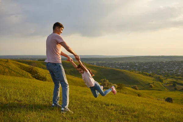 Kaygısız baba ve kız tepenin üstünde eğleniyor. — Stok fotoğraf